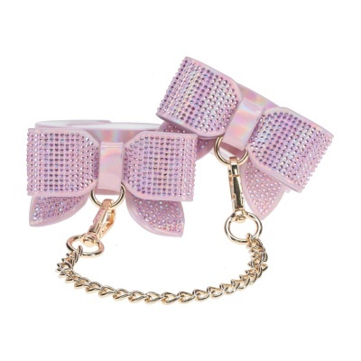Algemas decorativas cor-de-rosa com laços brilhantes e corrente dourada.