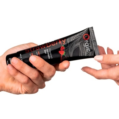 Tubo preto de gel íntimo aromatizado morango sendo passado entre duas mãos