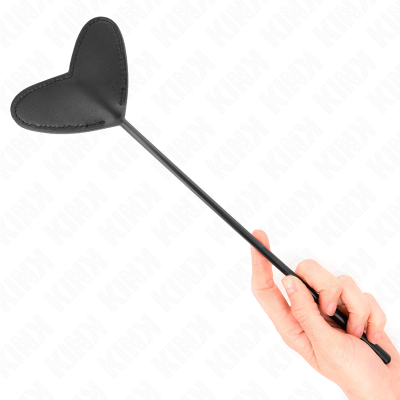 Chicote preto com pega em forma de coração segurado por uma mão.