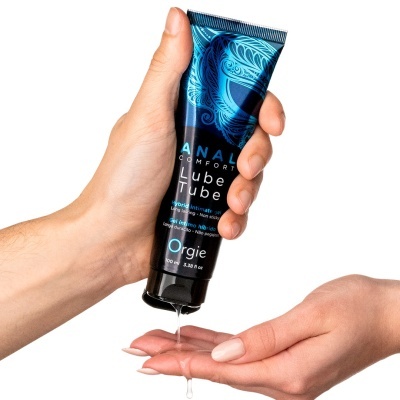 Duas mãos a aplicar gel lubrificante íntimo em tubo azul e preto Orgie