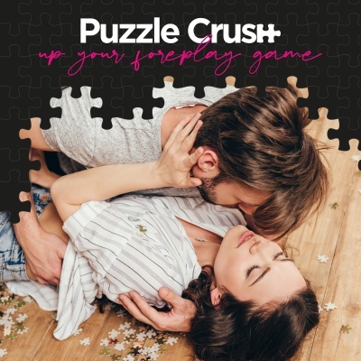 Casal a beijar-se sobre puzzle no chão de madeira com texto Puzzle Crush
