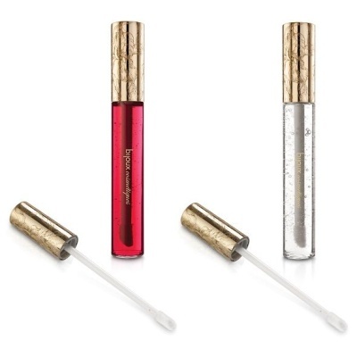 Dois tubos de verniz para lábios, um vermelho e outro transparente, com tampas douradas decoradas e aplicadores.