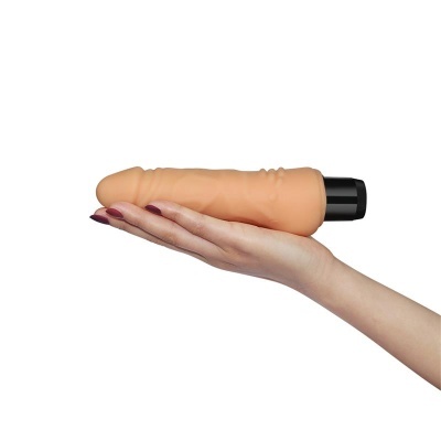Mão segurando vibrador cor nude com base preta