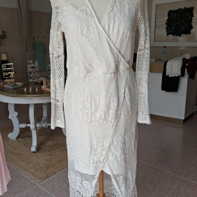 Vestido branco de renda com padrão floral e malha em manequim