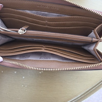 Carteira em couro castanho com interior organizador e padrão Michael Kors