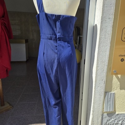 Macacão azul numa entrada de loja com manequim branco