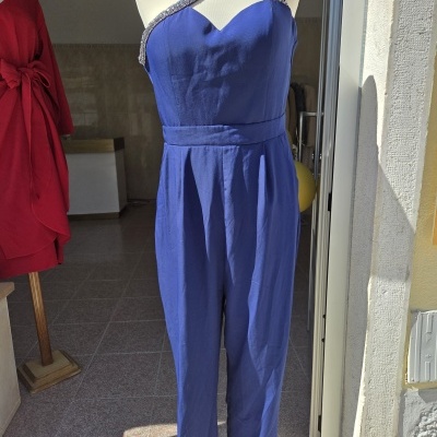 Macacão azul com um ombro só e pedraria exposto em manequim