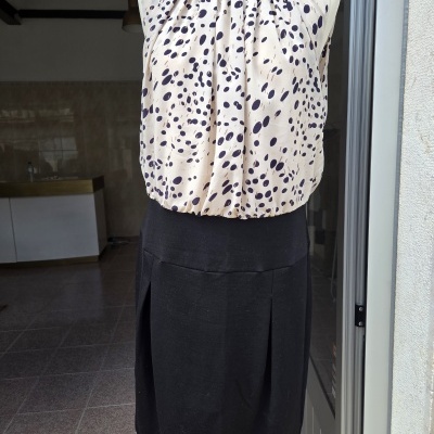 Vestido sem mangas com parte superior bege com pintas pretas e castanhas e parte inferior preta em manequim branco