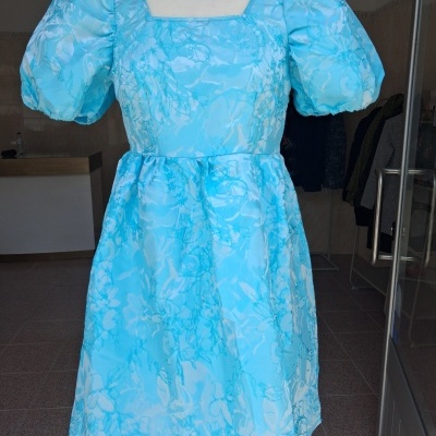 Vestido azul claro floral com mangas bufantes num manequim