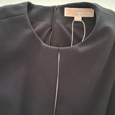 Peça de roupa preta com etiqueta MICHAEL MICHAEL KORS e fecho na parte de trás