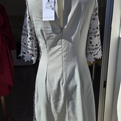 Vestido cinzento claro com mangas em renda floral e etiqueta LITTLE MISTRESS num manequim.