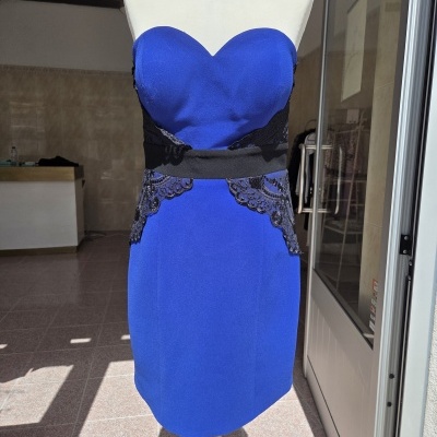 Vestido curto azul royal com renda preta exibido em manequim