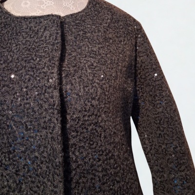 Casaco cinza escuro com lantejoulas sobre manequim