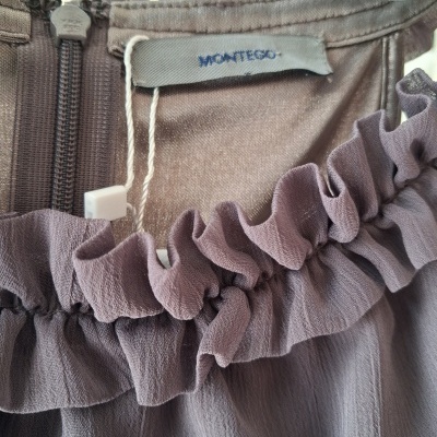 Detalhe de vestido roxo com gola franzida e etiqueta MONTEGO