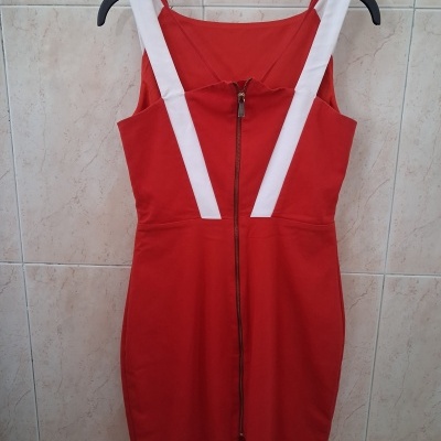 Vestido vermelho com alças brancas pendurado num cabide preto