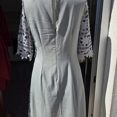 Vestido cinza claro com mangas em renda branca floral visto pelas costas