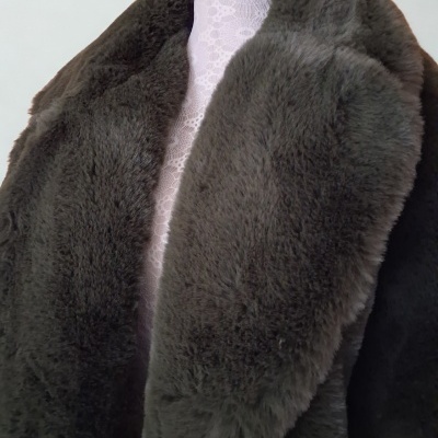 Casaco castanho de pêlo sintético com gola larga sobre tecido branco com renda