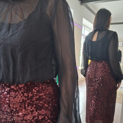 Blusa preta semi-transparente e saia midi com lantejoulas vinho vista frontal e de costas no espelho