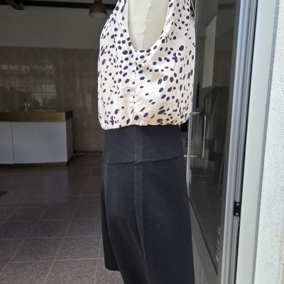 Vestido sem mangas creme com manchas pretas e parte inferior preta em manequim