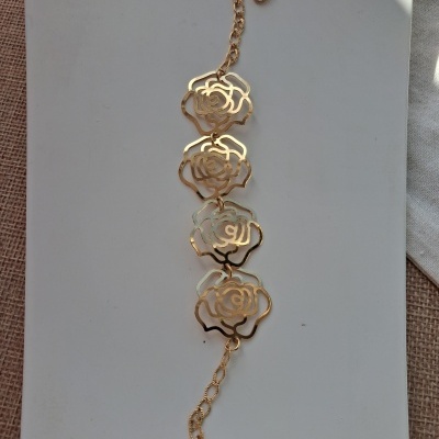 Pulseira dourada com flores recortadas em metal