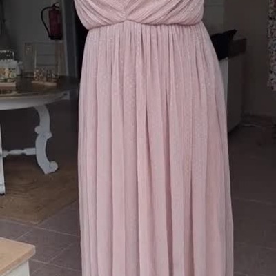 Vestido rosa claro plissado com alças finas mostrado num manequim