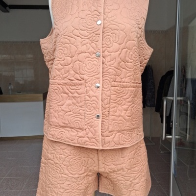 Conjunto almofadado cor de pêssego com padrão de flores e botões prateados