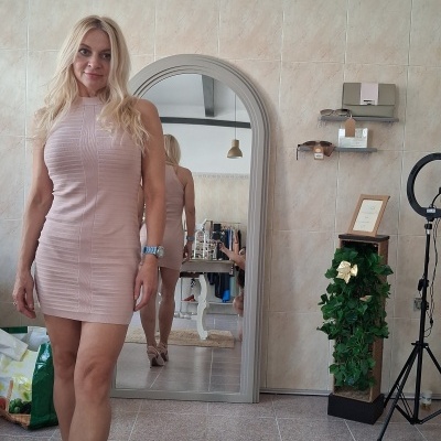 Vestido justo rosa claro com sapatos nude e espelho alto em ambiente com azulejos bege