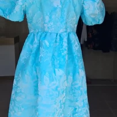 Vestido azul claro com laço no pescoço exibido num manequim