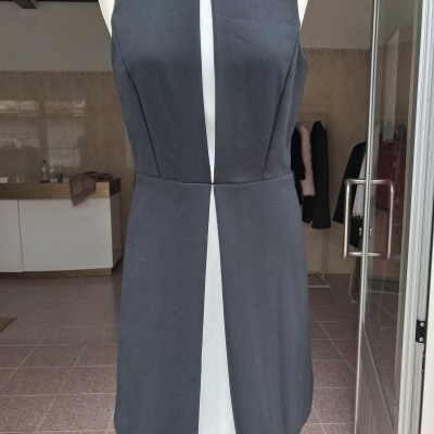 Vestido preto sem mangas em manequim branco numa loja.