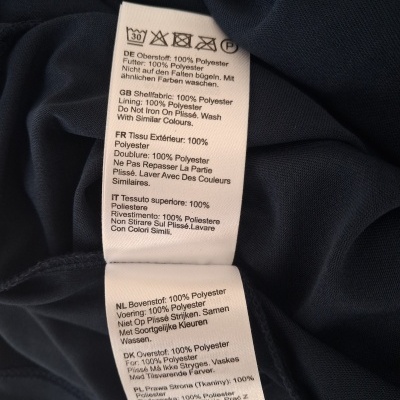 Etiqueta de roupa branca com instruções em tecido azul escuro.