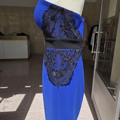 Vestido azul com renda preta e faixa preta à cintura em manequim
