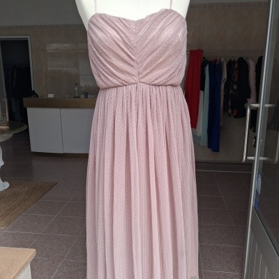 Vestido rosa claro com alças finas e saia plissada exposto em manequim