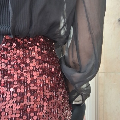 Saia de lantejoulas cor de vinho com blusa preta transparente de mangas compridas