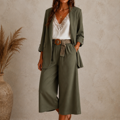 Conjunto verde-oliva com blusa branca e sandálias castanhas em ambiente neutro