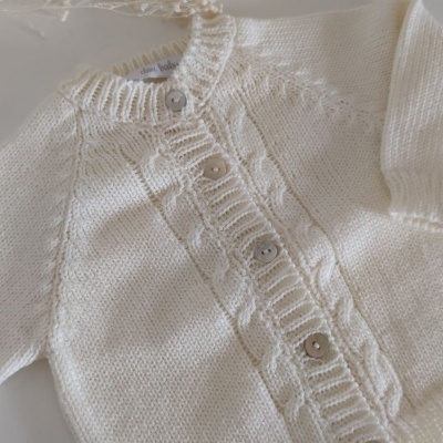 Camisola de bebé branca em malha com botões e padrão de trança