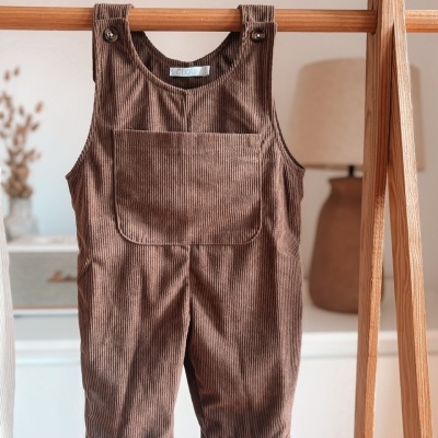 Jardineira castanha de bombazina pendurada em cabide de madeira