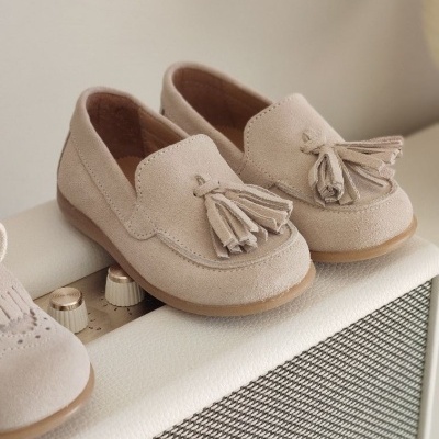 Sapatos mocassim bege com borlas em cima de amplificador Marshall