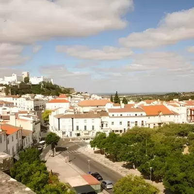 Vista aérea de cidade com castelo na colina, edifícios brancos e telhados vermelhos