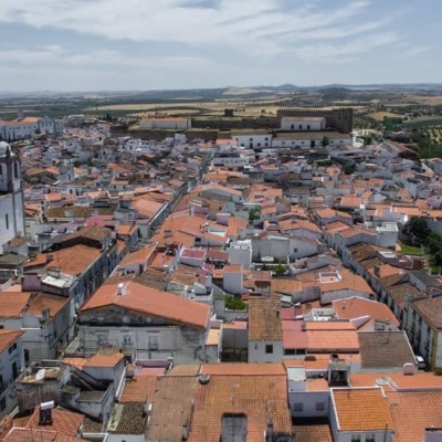 Vista aérea de cidade com telhados laranja e igreja com torres