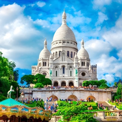 Basílica do Sacré-Cœur em Paris com carrossel e multidão em dia claro