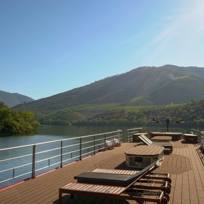 Convés de madeira com espreguiçadeiras e paisagem natural