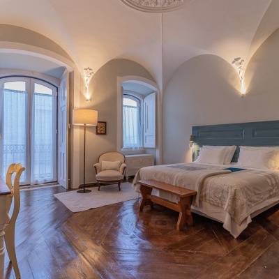 Quarto com cama de casal, cabeceira azul e móveis em madeira