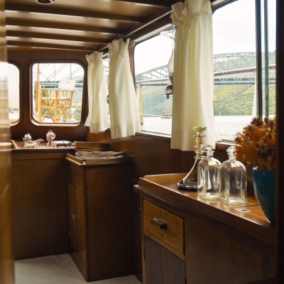 Interior de barco com móveis de madeira e cortinas brancas