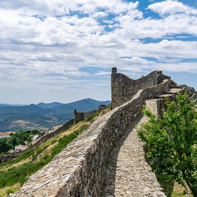 Caminho de pedra e muro de pedra em castelo histórico com paisagem verde