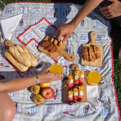 Cobertor de piquenique com comida e bebida sobre relva
