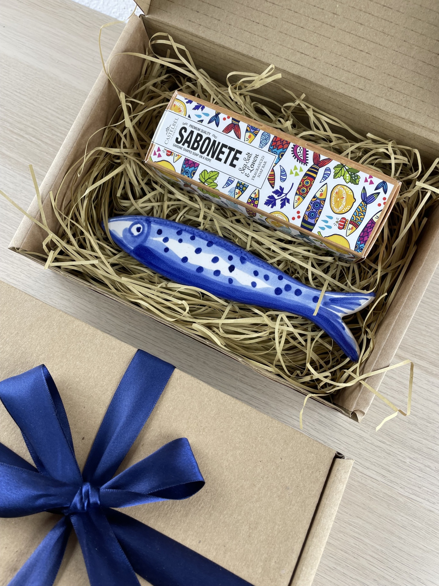 Gift box with SABONETE soap and blue ceramic fish soap holder inside.