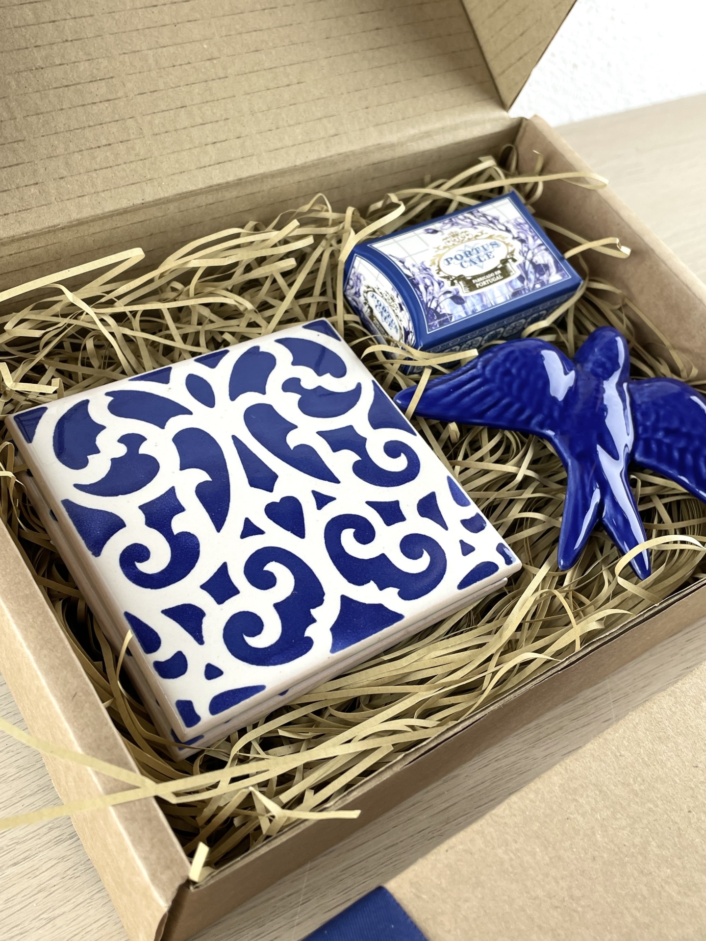 Gift box with blue and white ceramic tile, blue ceramic bird, and Portuguese cake box