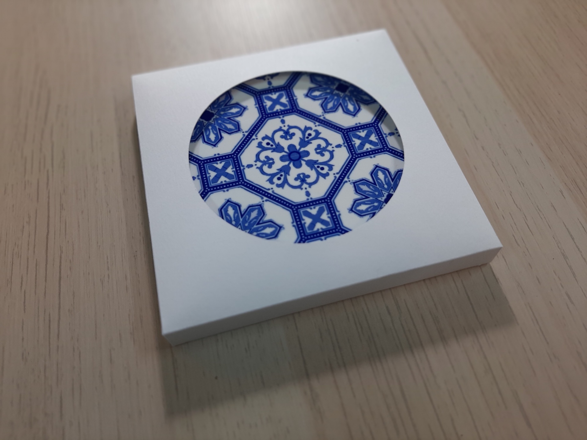 Blue and white ceramic plate with floral pattern inside white square box