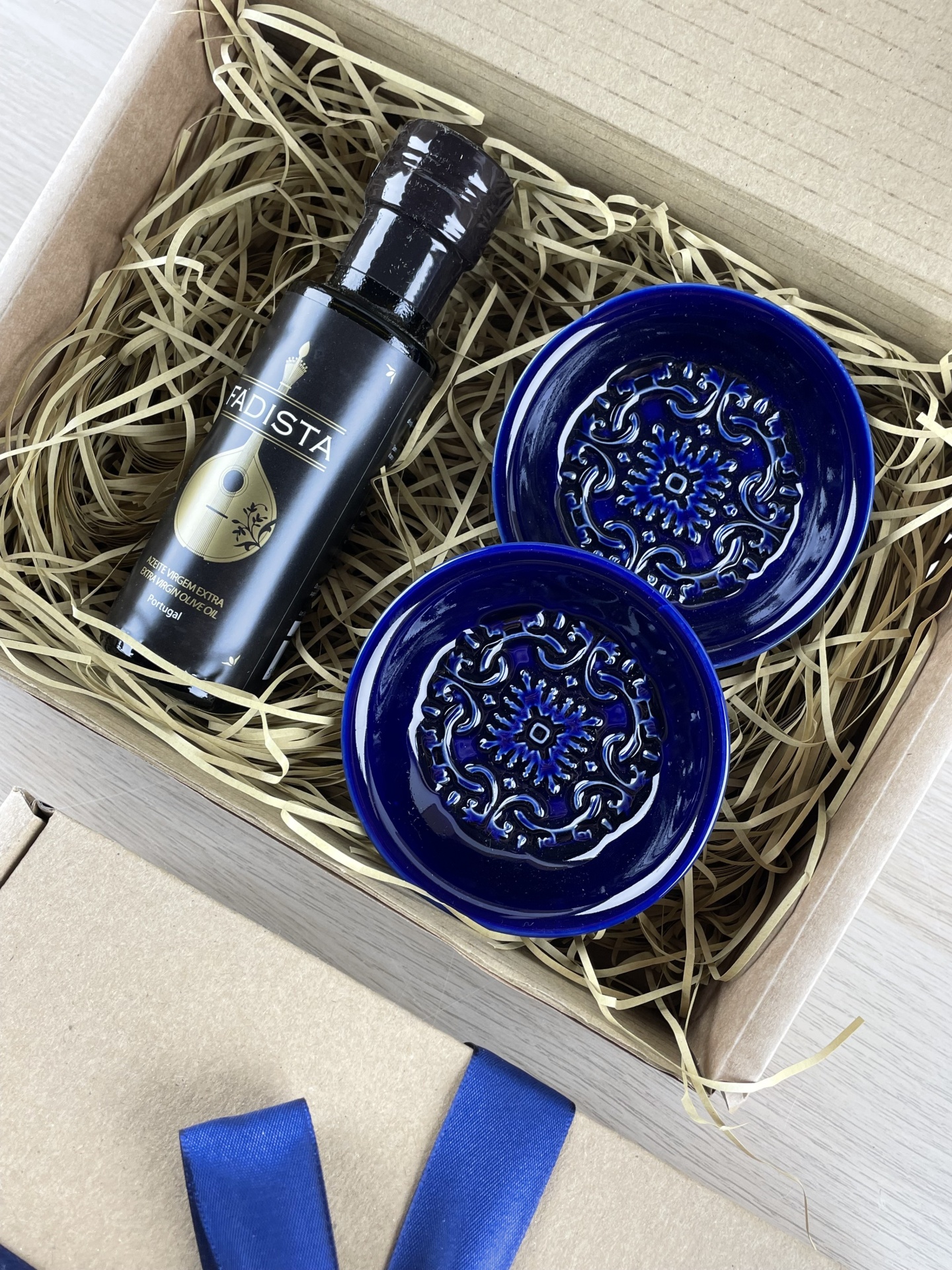 Gift box with black bottle of Fadista extra virgin olive oil and two blue embossed ceramic dishes