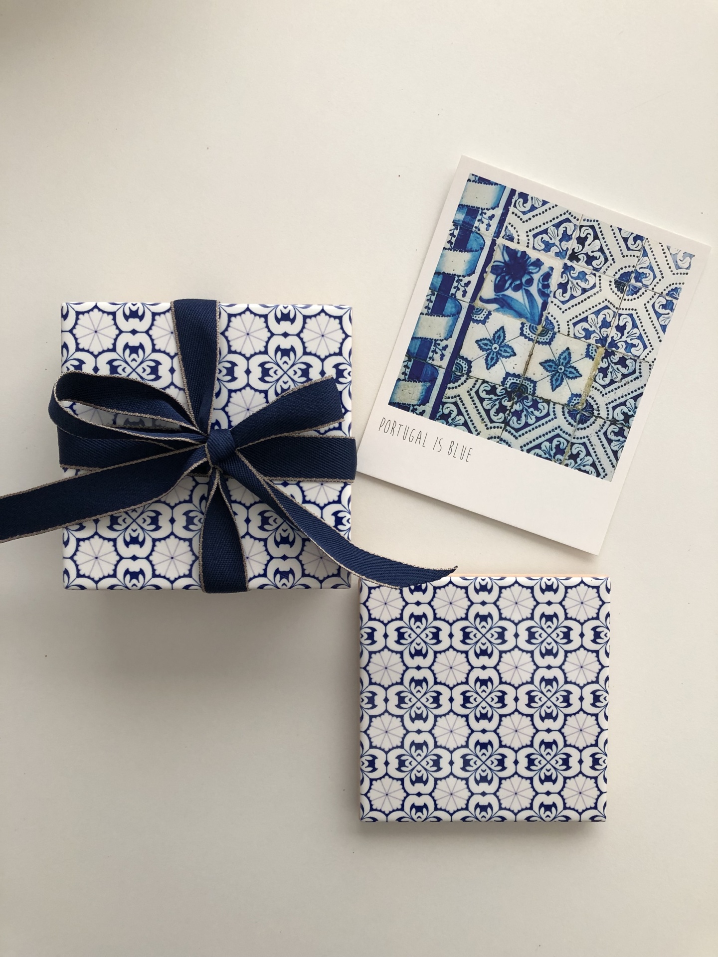 Two patterned blue and white gift boxes and a card with blue tile designs on a white background